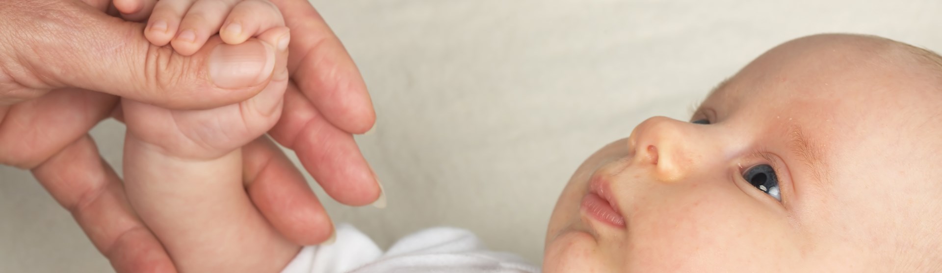 Baby hält die Hand der Mutter